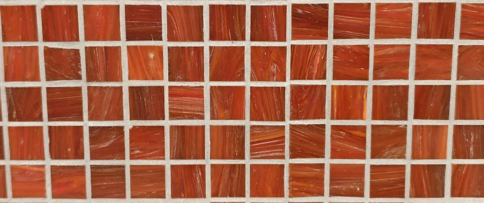 Close‑up of a mosaic composed of reddish‑orange square tiles Фото