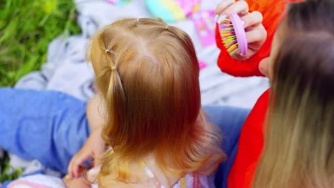 Close-up of a mother combing her daughter's red hair. Stock Footage 253803227