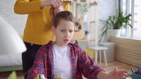 Close up mother combs her daughter's hair Video stock 105609437