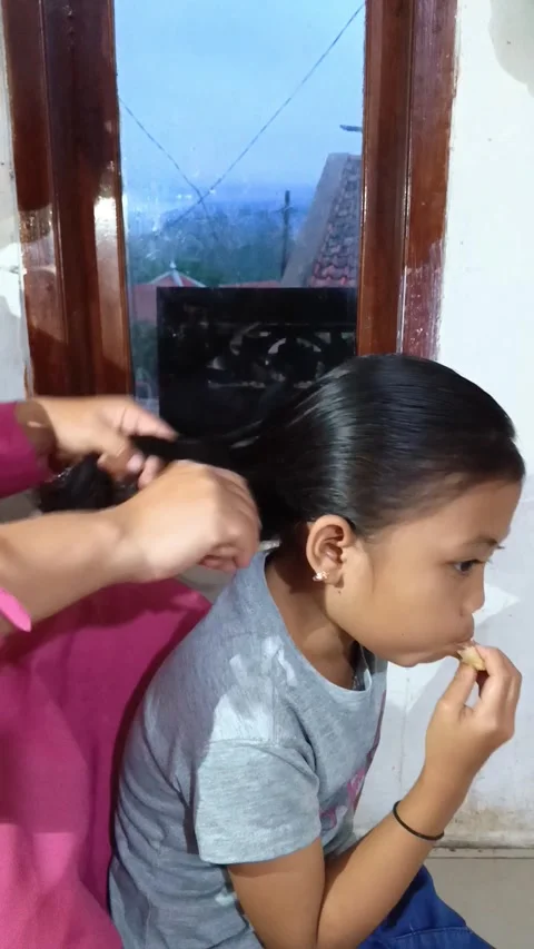 Close-up of a mother gently combing her daughter's long. Stock Footage 321941166
