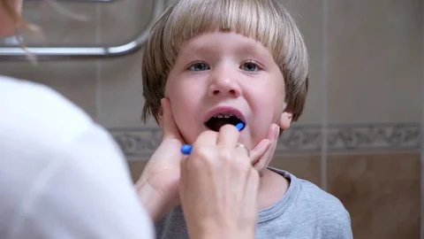 Close-up mother helps to clean the teeth to her little son in the morning. Woman Vídeos de archivo 111760759