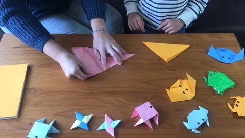 Close-up of a mother with her son while they are at home doing origami crafts 動画素材 127746236