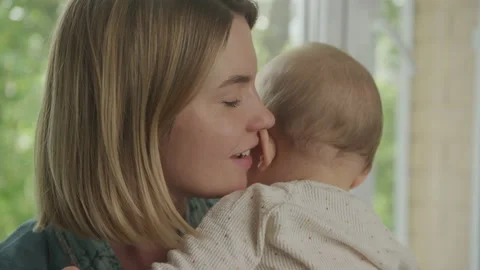Close up of a mother hugging her son and looking at camera with a smile 動画素材 205063373