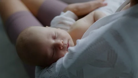 Close-up, mother puts her newborn baby to sleep, rocking him in her arms Stock Footage 306016040