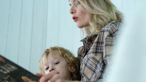 Close-up mother reading a book to her son Video stock 296445534