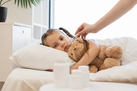 Close up of mother using thermometer to sick little girl Stock Photos