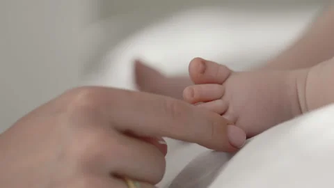 Close up of mother's hand touching bare feet of newborn baby Stock Footage 172240711