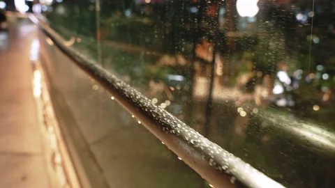 Close up motion along Urban elevated walkway handrail with Raindrops Offering Stock Footage 315018016