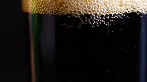 Close up motion of dark soda bubbles settling in transparent glass creating.. Stock Footage 333811166
