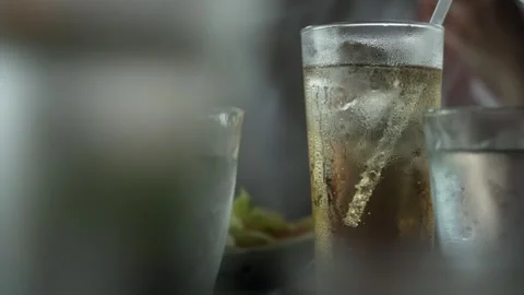 Close up motion footage of a refreshing cold drink with ice and a straw, co.. Video stock 337751685