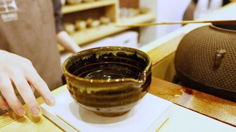 Close up motion of matcha green tea powder being placed into ceramic bowl w.. Stock Footage 333188916