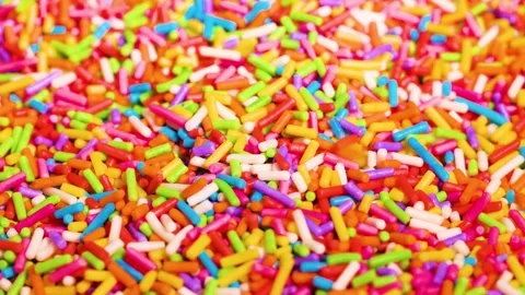 Close up motion of rainbow sprinkles falling onto pile of colorful confecti.. Stock Footage 333488567
