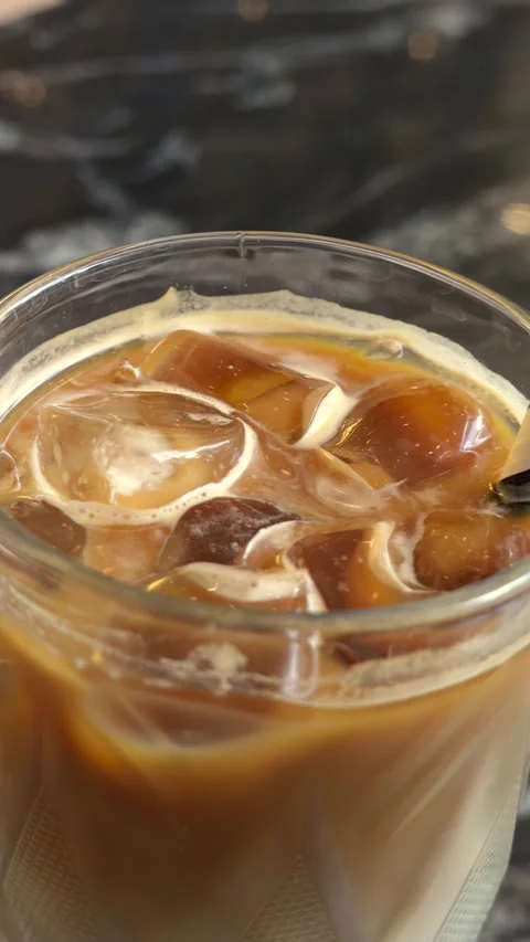 Close up motion of refreshing iced latte drink with milk and coffee on a da.. Stock Footage 339376230