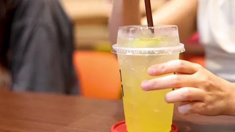 Close up motion shot of hand stirring refreshing yellow sparkling beverage .. Stock-Footage 332593065