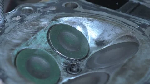 Close-up motorcycle engine cylinder head, showing clean, circular valves going Stock Footage 312033011