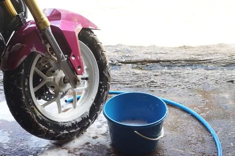 Close-up of a motorcycle front wheel being washed with soap and water beside a b Fotos Stock