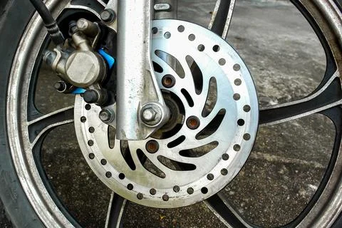 Close-up of motorcycle front wheel with disc brake rotor and caliper Stock Photos