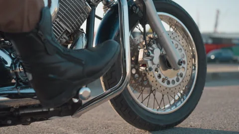 Close Up of Motorcycle Front Wheel with Rider Leg on Bike Stand Stock Footage 321118443