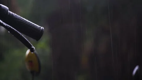 Close up of motorcycle handlebar during heavy summer rain storm in nature Video stock 342331485