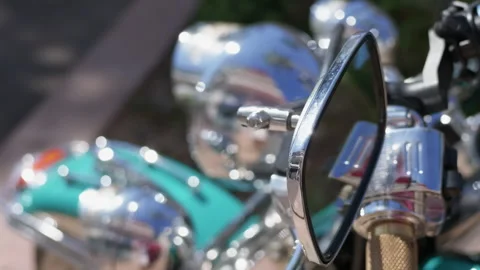 Close-up of a motorcycle side mirror with blurred chrome headlights in the Stock Footage 344822861