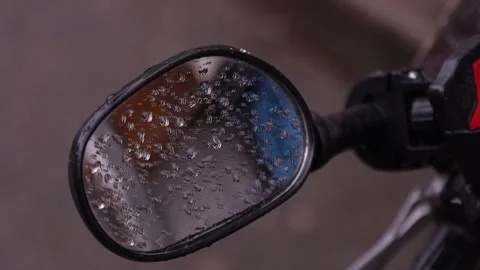 Close up of a motorcycle side mirror covered in raindrops Vidéo 342654759