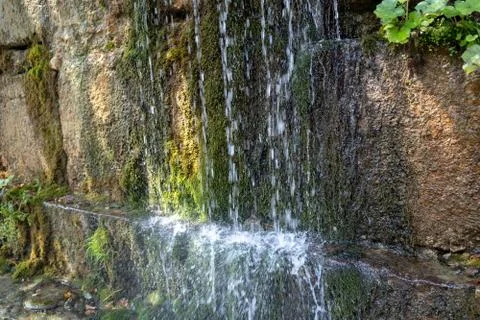 Close up of mountain stream flowing down in summertime. Manmade decorative Stock Photos