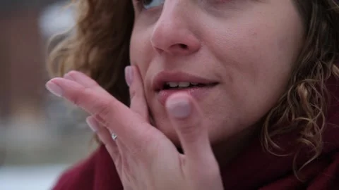 Close-up of the mouth and teeth of a smiling woman, outdoors in winter. White Stock Footage 258465509
