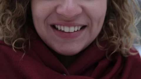 Close-up of the mouth and teeth of a smiling woman, outdoors in winter. White Stock Footage 258465630