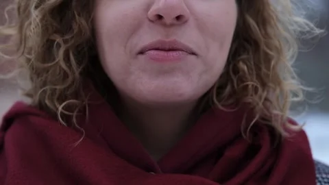 Close-up of the mouth and teeth of a smiling woman, outdoors in winter. White Stock Footage 258659528