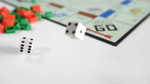 Close up of moving dice on a board game of red and green shaped playing piece Stock Footage 89188590