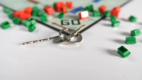 Close up of moving double dice and house keys scattered onto a board game  Stock Footage 89188662