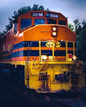 Close up of the moving orange train under the moody sky Stock Photos