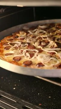 Close-up: mozzarella, pepperoni and onion pizza baking inside the oven. Hot food Fotos de archivo