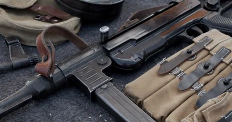 Close-up of MP 40 German WWII submachine gun with ammo pouches on table. Stock Footage 313834003