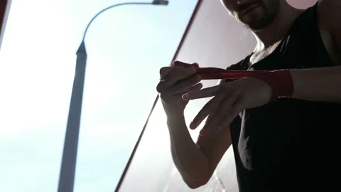 Close-up of muay thai boxer pulling bandages on his hands outdoors Stock Footage 94056584