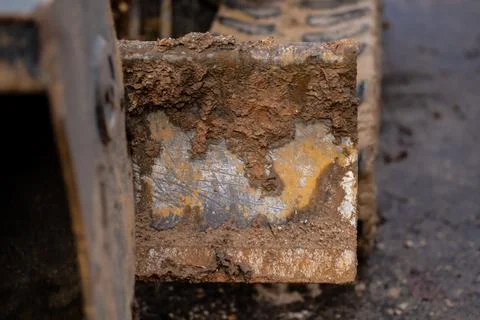 Close-up of mud-covered excavator blade showing rough texture, steel surfac.. Foto stock