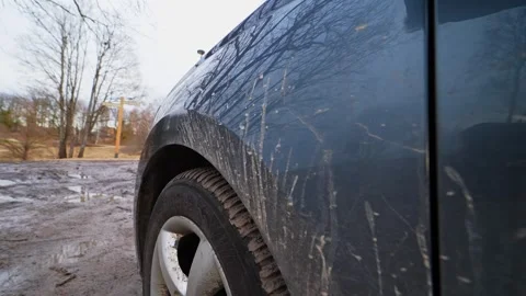 Close-up of mud splatter on a dark vehicle body and wheel after driving through Stock Footage 332736586