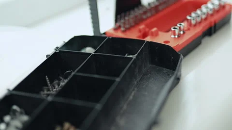 Close-up of a multi-bit screwdriver, nails, and boots in a plastic organizer, ho 스톡 동영상 335644227