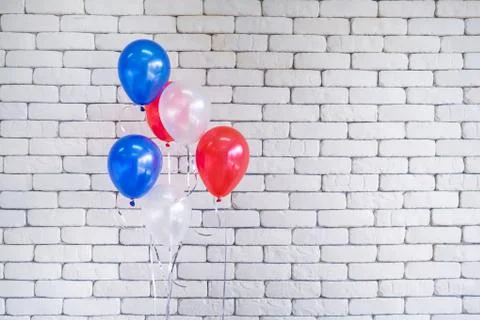 Close-up of multi colored balloons against white brick wall background Stock Photos