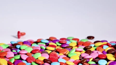 Close Up of Multi Colored Chocolate Candies Falling onto a Pile Stock Footage 328139171