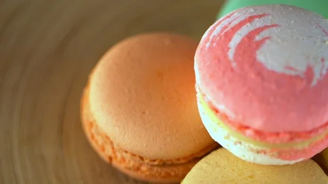 Close-up of multi-colored French macaroons lie on a brown plate Stock Footage 120606927