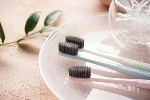 Close-up. Multi-colored toothbrushes and cotton buds on a beige background. Stock Photos