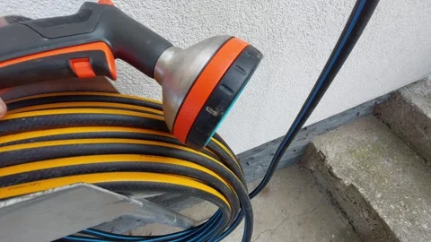 Close-up of multi-function garden hose spray nozzle and reel Video stock 333642782