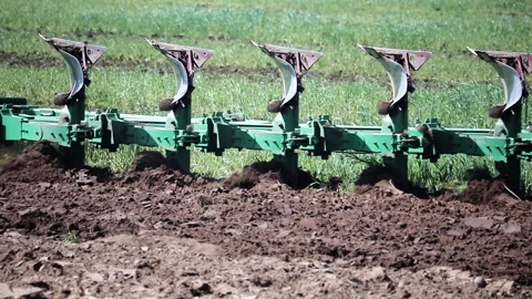 Close up of a multi plow cultivating the soil during field work Stock Footage 135112882