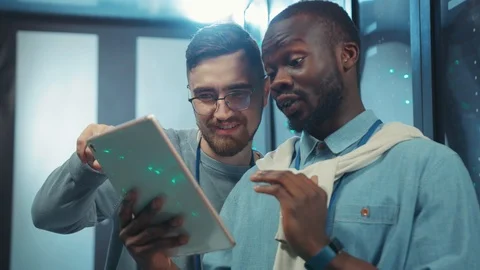 Close-up multi-race friendly engineers in data center using smartphone browsing Stock Footage 119843457