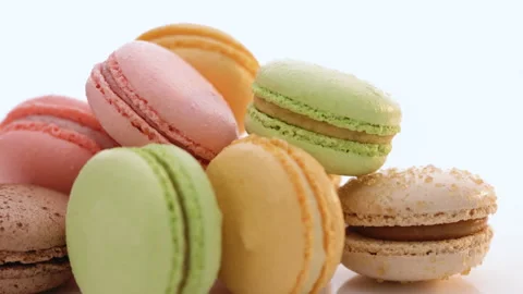 Close up of multicolor macarons French macaroon greedy pastry rotate on white Stock Footage 194843217
