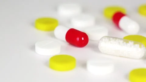 Close-up of multicolored medicines rotating on white table Stock Footage 136472261