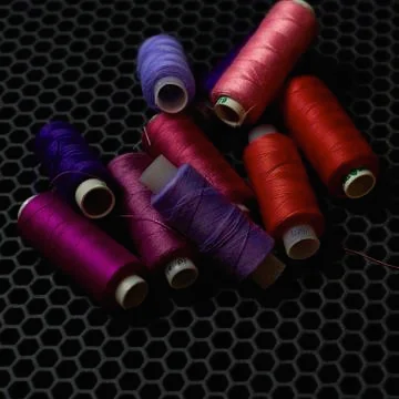Close-up multicolored threads on a dark background from above Stock Photos