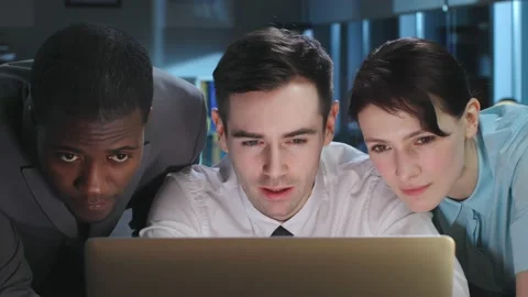 Close up of multiethnic colleagues looking at laptop screen and discuss smiling Stock Footage 176797908