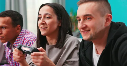 Close up of multinational group of college students sit on the couch and play Stock Footage 152387921